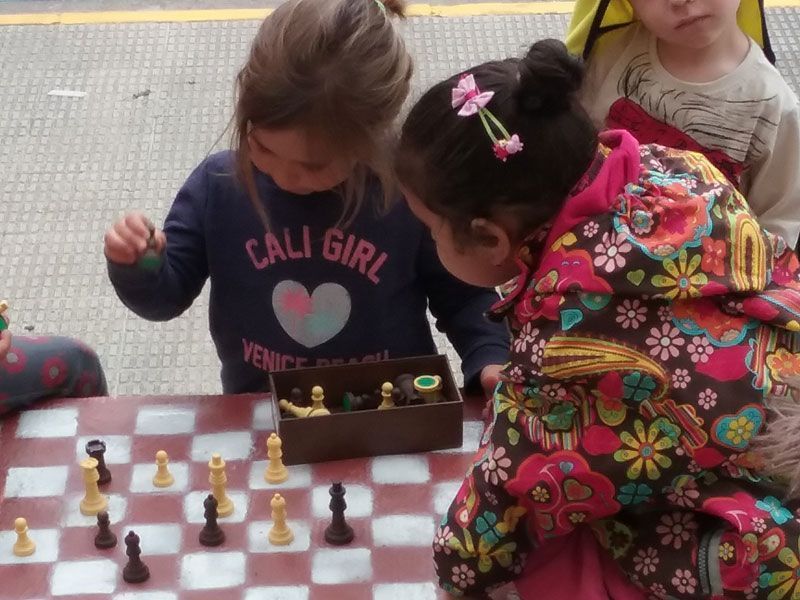 Alumnos jugando al ajedrez en el patio del recreo