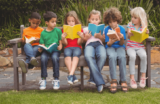 niños leyendo en banco