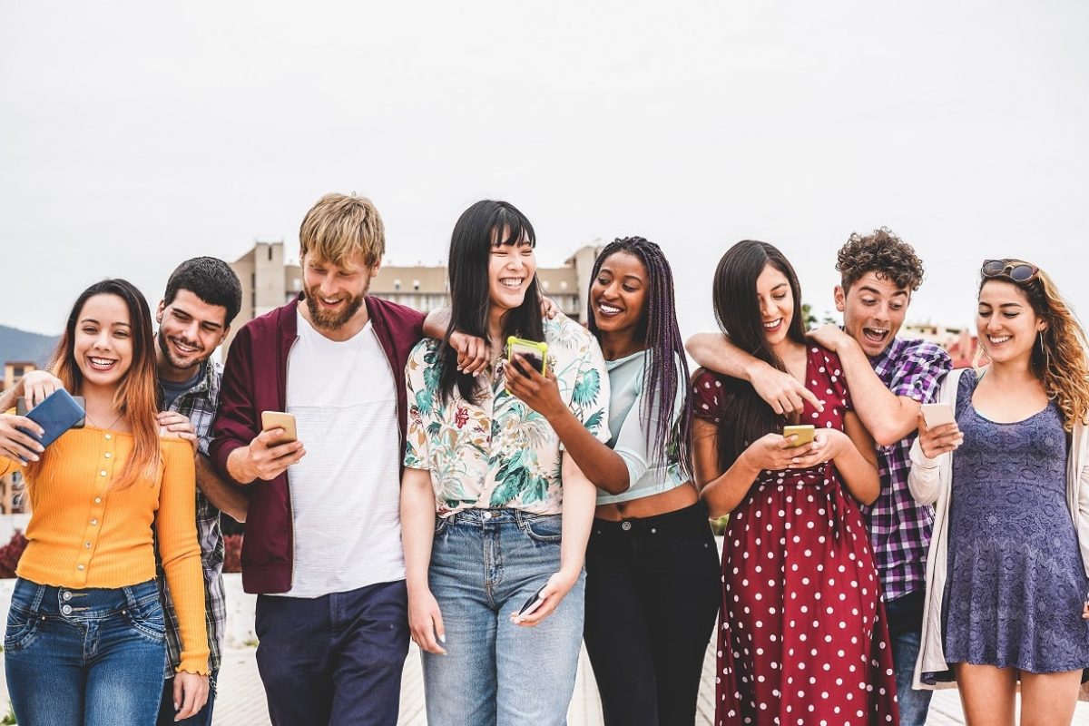 Los millennials, gurús tecnológicos de sus familias Un grupo de millennials se lo pasa bien con los moviles