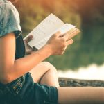 mujer lee al lado de un río