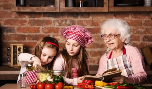 Dos niñas siguen una receta con su abuela