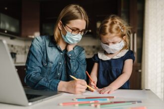 Madre e hija estudian con mascarilla en casa - coronavirus