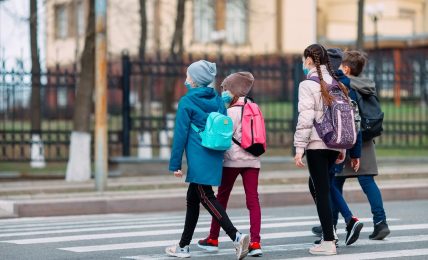 Niños de camino al colegio con mascarilla