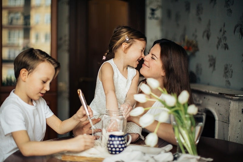 una madre pasa tiempo en familia con sus hijos - las familias mejoran la comunicación en confinamiento