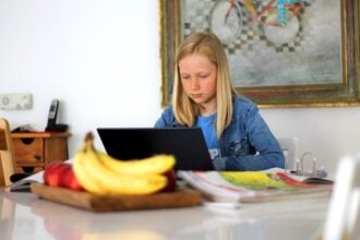 Una niña estudia en casa por ordenador