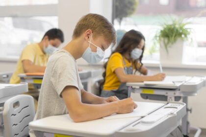 Niños estudiando en clase con mascarilla