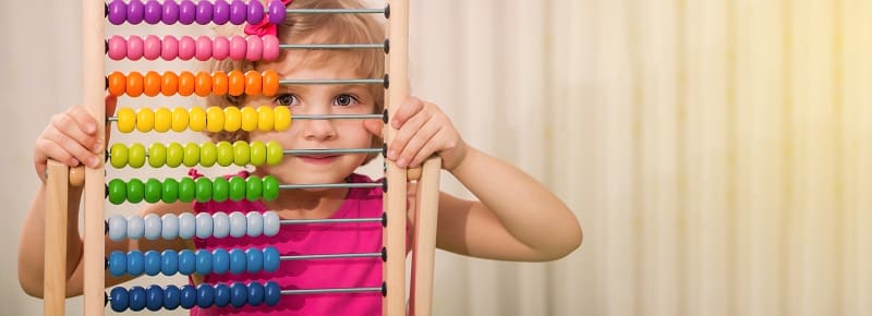 Una niña mira através de un ábaco