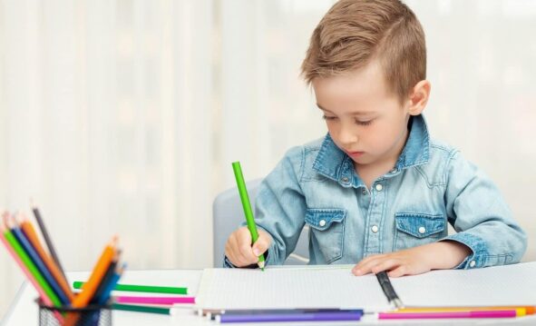 Un Niño Escribe A Mano Con Un Lapicero De Color Verde