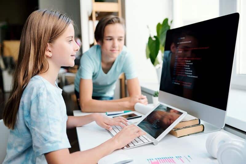 Una niña está escribiendo con el teclado. Escribir a mano mejora el aprendizaje. 