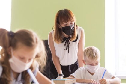 Profesora y alumnos con mascarilla en el aula