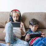 Niños juegan con consolas portátiles