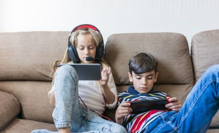 Niños juegan con consolas portátiles