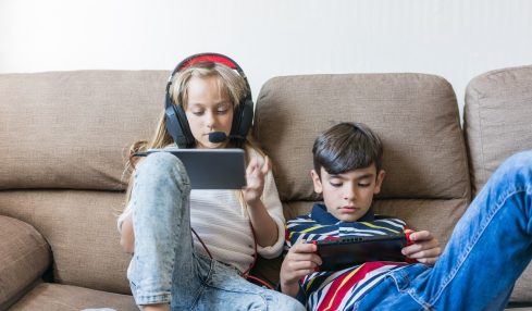 Niños juegan con consolas portátiles