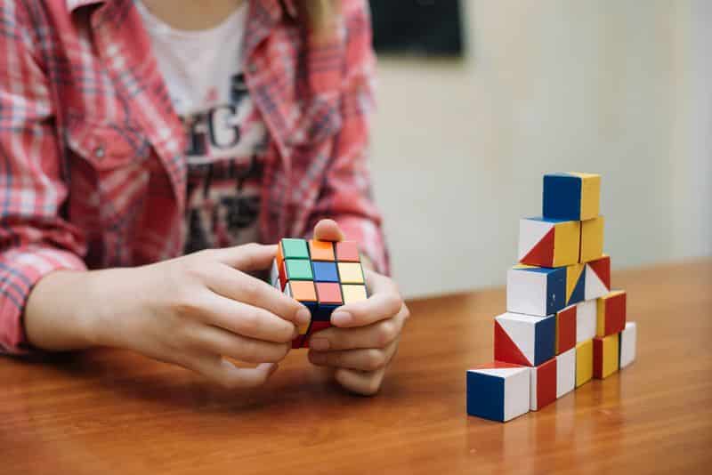 Una niña se concentra mientras juega con un cubo de rubik. 