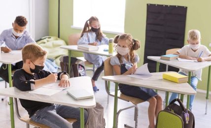 niños en una clase presencial con mascarilla