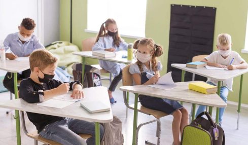 niños en una clase presencial con mascarilla