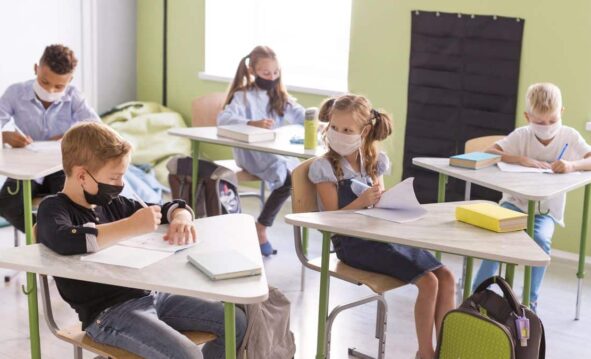 Niños En Una Clase Presencial Con Mascarilla