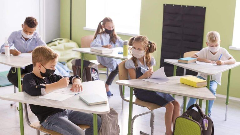 niños en una clase presencial con mascarilla