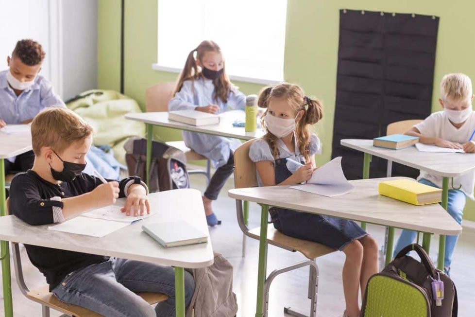 niños en una clase presencial con mascarilla