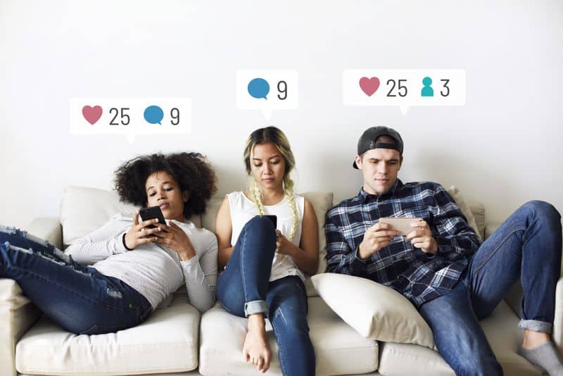 Adolescentes usando las redes sociales en sus móviles