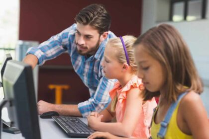 un profesor y sus alumnos usan un ordenador con soluciones de Microsoft centradas en la seguridad