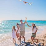 una familia juega con una cometa en la playa