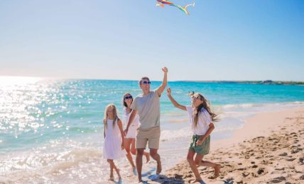 una familia juega con una cometa en la playa