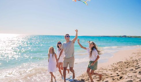 Una Familia Juega Con Una Cometa En La Playa