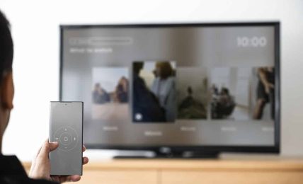 man changing tv channel by his smartphone