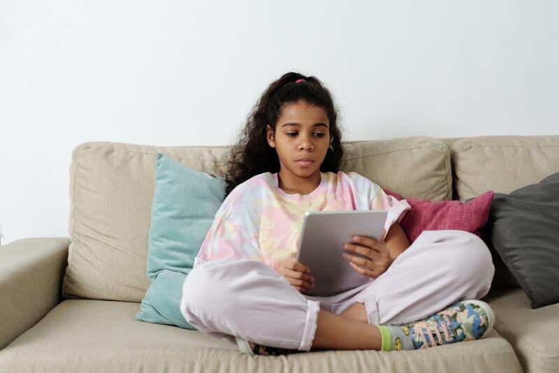 Una niña lee un libros en formato digital