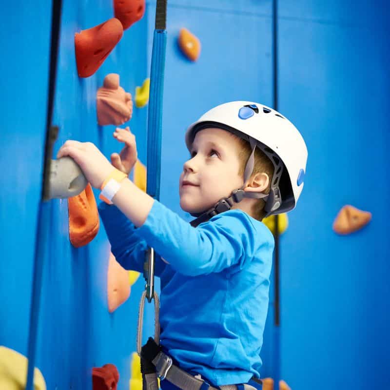 Niño escalando deportes de aventura