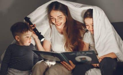 Familia leyendo bajo una sábana