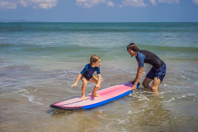 Instructor con niño surfeando deportes de aventura