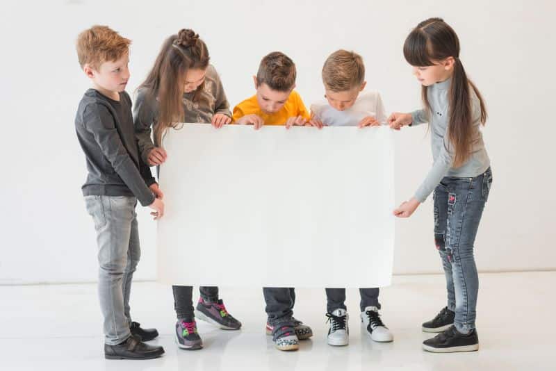 Niños Sujetando Un Cartel.