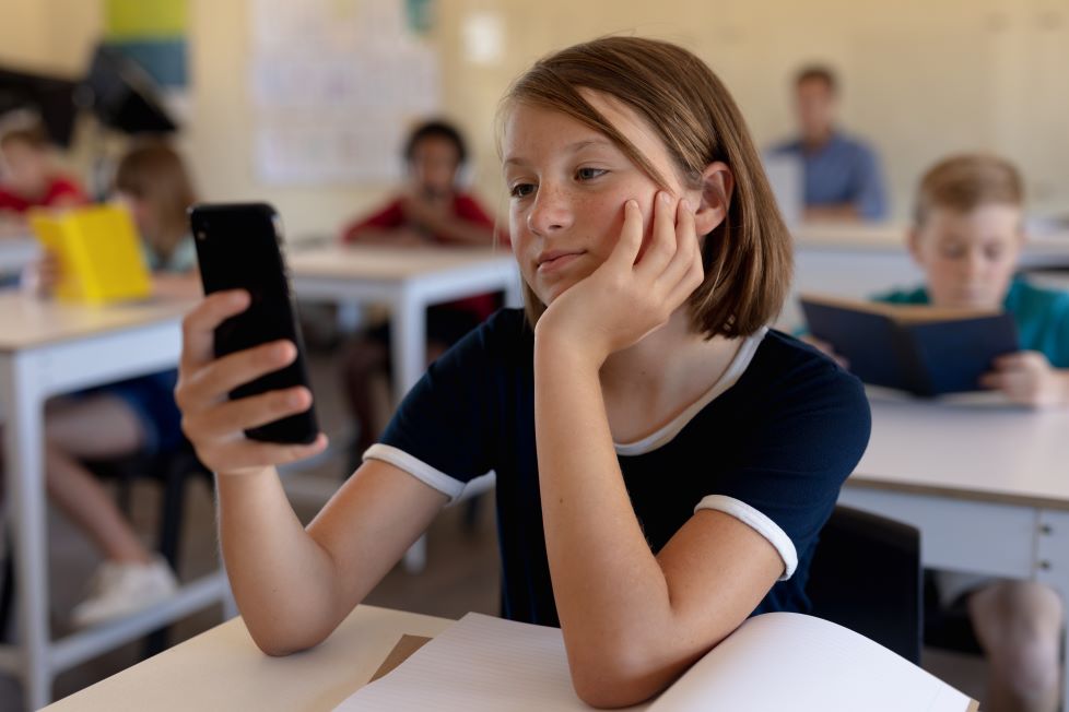 Niña Usando El Móvil En Clase.