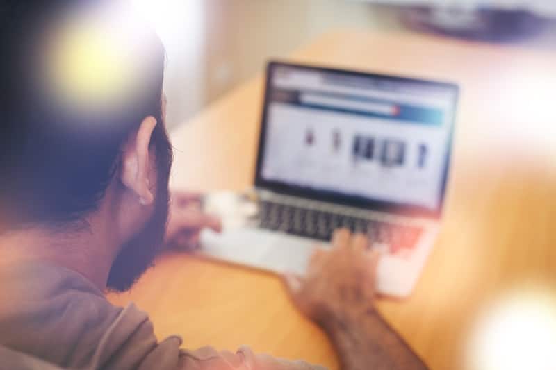 rear view man using laptop table